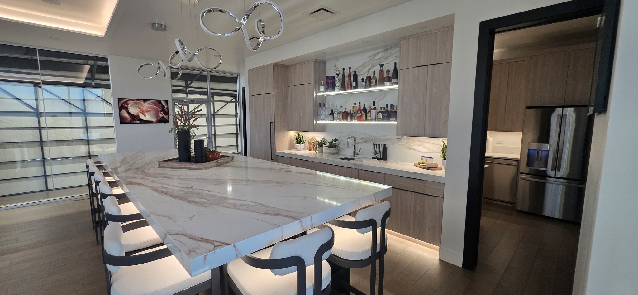 Kitchen island with marble top and backlit bar shelving in Missoula